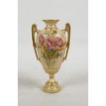 A Royal Worcester blush porcelain pedestal urn with two gilt embellished handles and painted with
