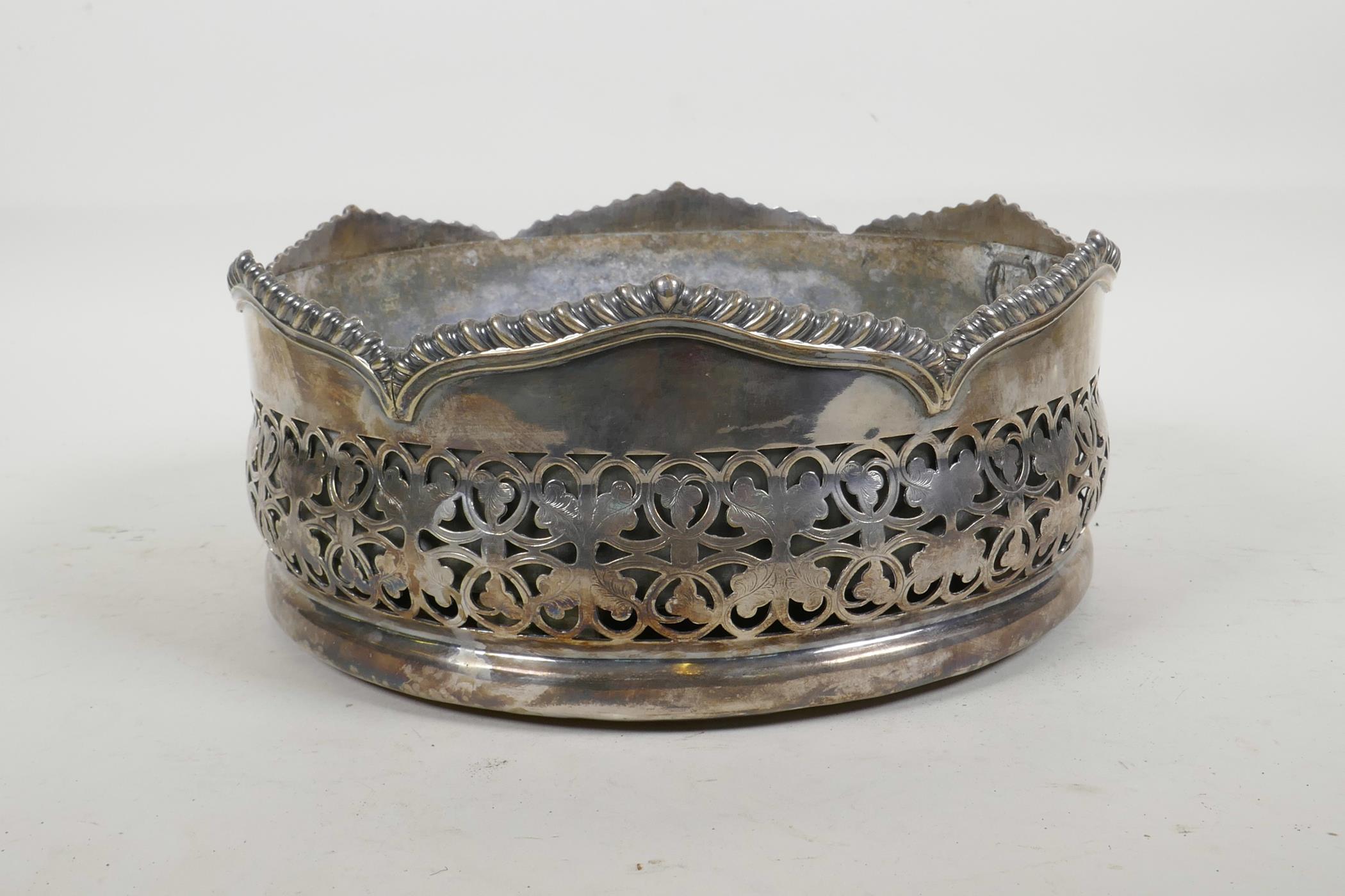 A silver plated table centrepiece coaster, with pierced foliate decoration and gadrooned rim, and