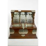 An oak tantalus with silver plated mounts, fitted with three cut glass decanters and fitted