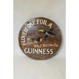 A wagon wheel table top with later painted 'Guinness' decoration, 32" diameter