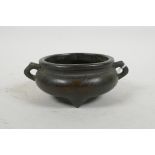 A Chinese bronze two handled censer raised on three supports, with cast character mark to base, 4"