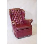 A mid century button back leatherette wing chair