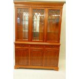 A Regency style yew wood display cabinet, with three astragal doors over three drawers and