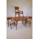 A mid century teak veneered dining table with extra leaf, raised on splay supports, with three