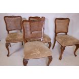 A set of four C19th French walnut chairs with shaped caned backs, raised on cabriole supports with
