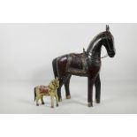 An Asian carved and painted figure of a horse with white metal harness embellishments, 16" high,