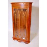 A bowfronted yew wood hanging corner cabinet with astragal glazed door, 22" x 41"