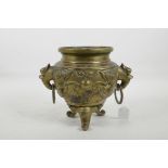 A Chinese polished brass censer with elephant mask ring handles, the body with embossed mythical