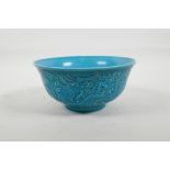 A Chinese turquoise glazed porcelain rice bowl with raised dragon decoration, seal mark to base,