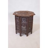 A Burmese carved hardwood octagonal occasional table with carved and pierced leaf design, 22"