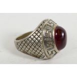 A Roman white metal ring set with cabochon red stone in a Greek Key mount, with crosshatched