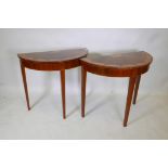 A pair of mahogany and satinwood inlaid demi-lune console tables, raised on square tapering