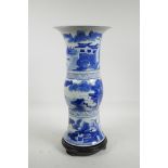 A Chinese blue and white Gu shaped vase decorated with figures in riverside landscapes, on a painted