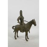 A Mongolian brass figurine of a warrior on horseback with bejewelled helmet, boots and horse tack,