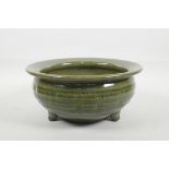 A Chinese olive green crackle glazed pottery bowl with tripod support, 9" diameter