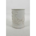 A Chinese cream ground porcelain brush pot with raised decoration of a monkey carrying a large
