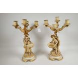 A pair of Victorian continental bisque candelabra, a boy and girl to the base, both holding a basket