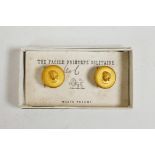 A pair of gilt cufflink studs with raised cherub decoration, West's patent