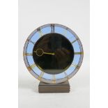 A vintage mantel clock with circular glass and brass case with exposed brass Roman numerals, 7"