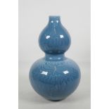 A Chinese blue glazed double gourd vase with self coloured embossed decoration, seal mark to base,