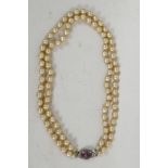 A Lotus two string pearl choker, with gem set silver clasp, 16" long