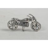 A white metal articulated motorcycle, 2" long