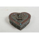 An Islamic white metal heart shaped box with figural decoration to cover, and inset turquoise and