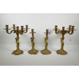 A pair of four branch gilt brass table candelabra, the stems cast as cherubs on a swirled base, with