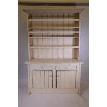 A C19th Irish painted pine dresser, with open rack over two drawers, and two cupboards raised on