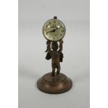 A brass ball desk clock being held aloft by a cherub, 4" high