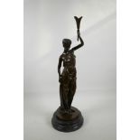 A classical style bronze figure of a lady holding a torch aloft, mounted on a turned marble socle,