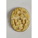 A C19th Cantonese carved ivory brooch in a 9ct gold mount, with carved decoration of figures in a