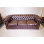 A three seat brown leather Chesterfield sofa, 78" x 35"