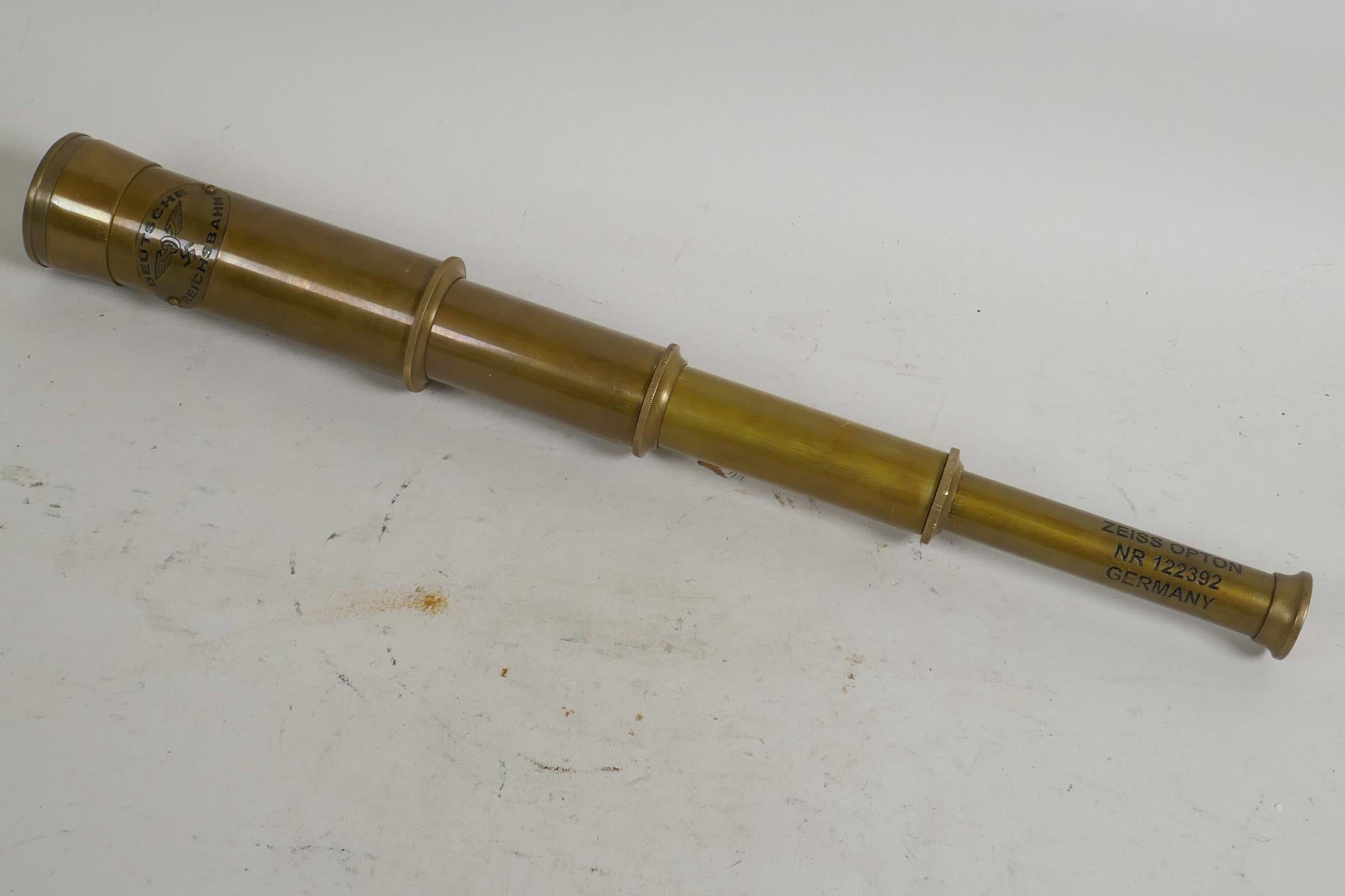 A brass cased three draw telescope marked Zeiss Germany, 6" long closed