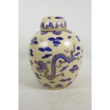 An oriental cream ground ginger jar and cover decorated with gilt embellished blue dragon and