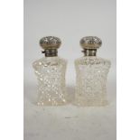 A pair of Edwardian cut glass dressing table bottles with silver tops, hallmarked Birmingham 1902,