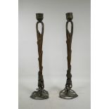A pair of Art Nouveau bronzed and gilt candlesticks, 26" high