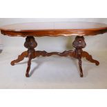 A twin pillar dining table with burr walnut inlaid top, raised on carved supports united by a
