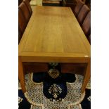 A contemporary oak dining table, raised on square tapering supports (detachable) and a set of