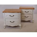 A pair of French style painted bedside chests with shaped tops, two drawers, raised on cabriole