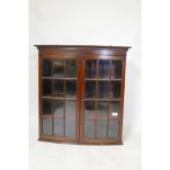 A mahogany bowfronted hanging cabinet with two leaded light doors, early C20th, 24" x 9" x 27"