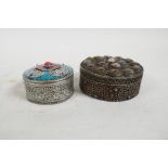 Two Islamic white metal circular boxes with inset stones and scrolling decoration, largest 3"