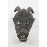 An Ethnic wood mask, carved as a ferocious beast, 14" long