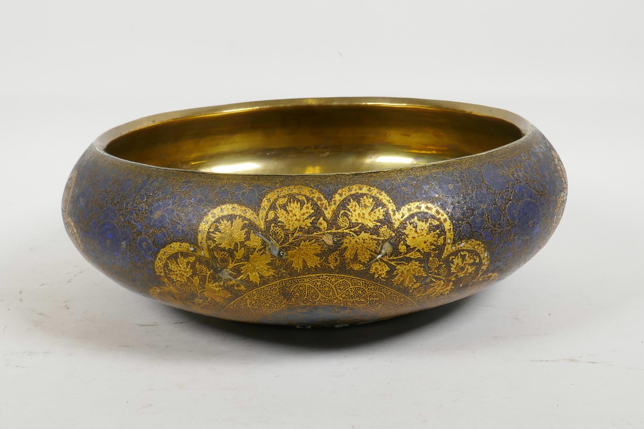 A Kashmiri brass and lacquer bowl with a rolled rim, decorated with gilt floral patterns, signed