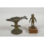 A small Indian bronze figure on a wood stand, 4½" high, together with an engraved brass oil lamp