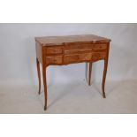 A French mahogany shaped top dressing table with rising centre section over writing slide, with four