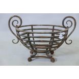 A cast iron fire basket, raised on scroll supports with scroll decoration, 12" x 25" x 18"