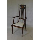 An Art Nouveau walnut high back open armchair, with inlaid and pierced back, and scroll end arms,