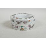 A Chinese polychrome porcelain doughnut shaped box and cover decorated with butterflies and flowers,