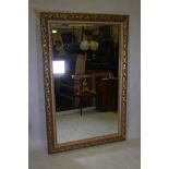 A large gilt composition wall mirror with swag and leaf moulding, 45½" x 69"